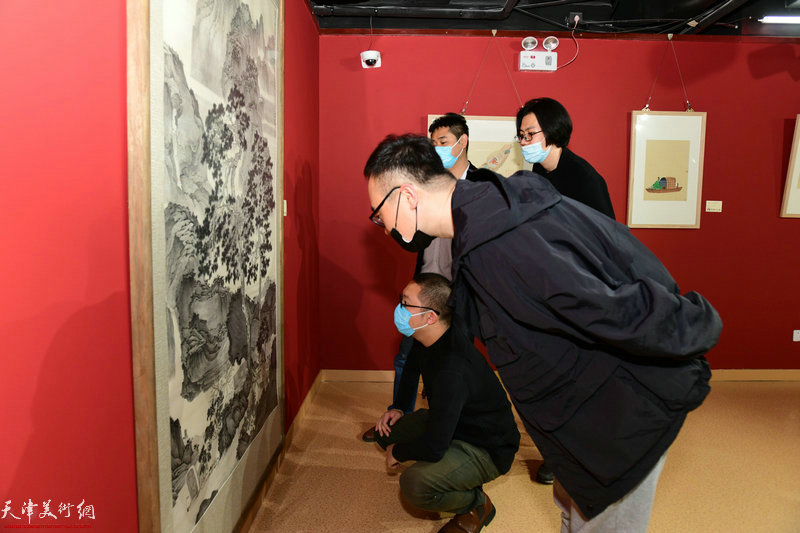 刘观岳、黄易非、刘天艺观赏展出的画作。