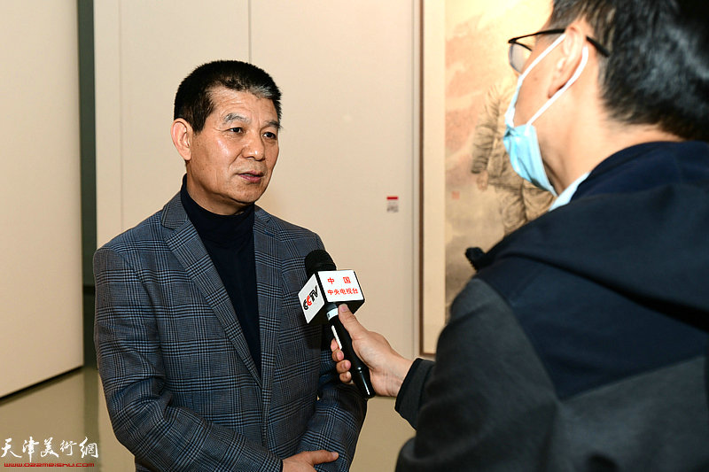 范扬在画展现场接受央视记者采访。