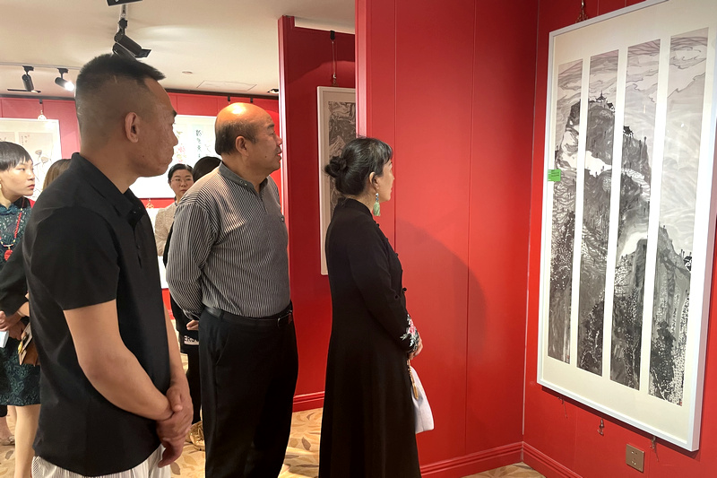 孟庆占、刘凤华、张建在画展现场观赏画作。