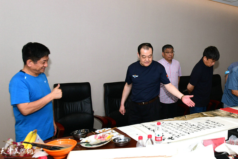 王冠峰向陈克春介绍创作的作品。