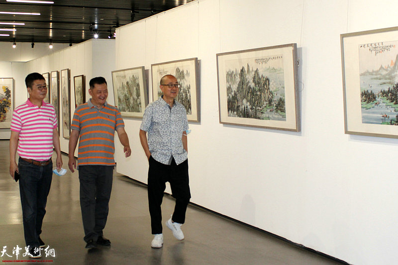 白鹏、马驰观赏展出的画作。