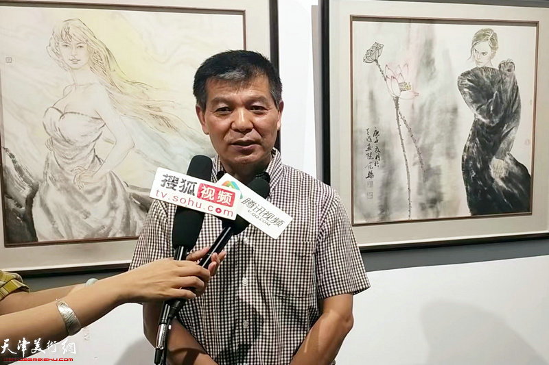 范扬在画展现场接受媒体采访。