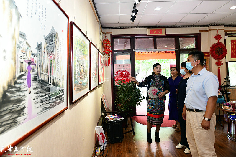 王蔓榕陪同张驰、郭雪娥观赏展出的作品。