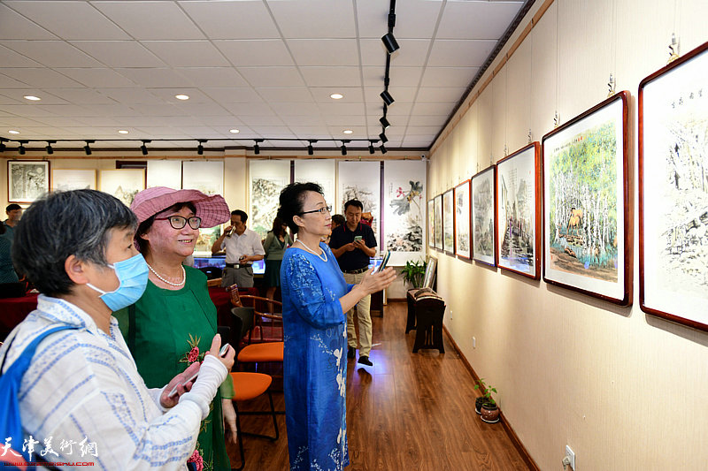 董志红等来宾观赏展出的作品。
