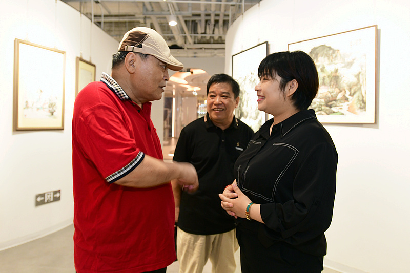 李耀春、李英杰、贾茹在画展现场交流。