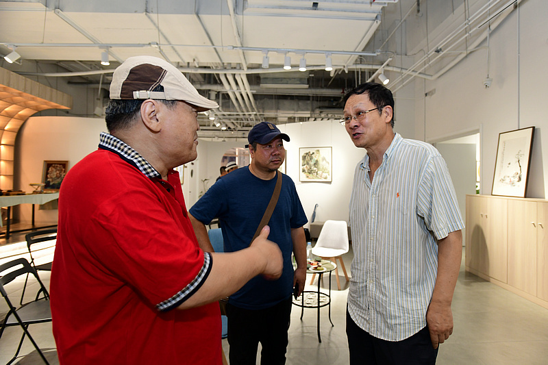 潘津生、李英杰、侯金利在画展现场交流。