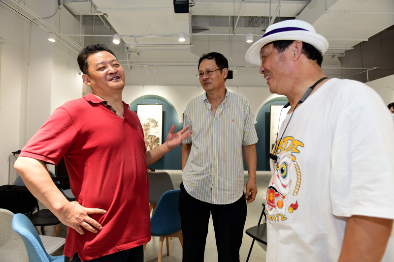 潘津生、李英杰、侯金利在画展现场交流。