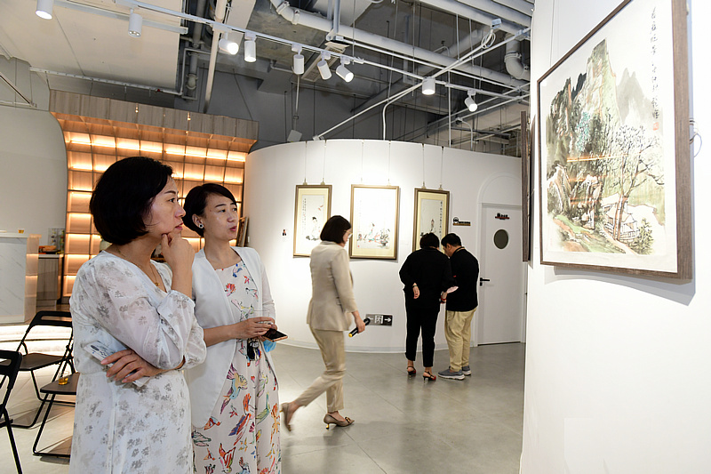 来宾在画展现场观赏展出的作品。