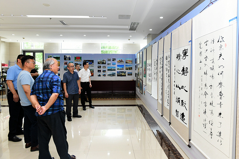 王书平与参加活动的书画家观看职工书画摄影展。