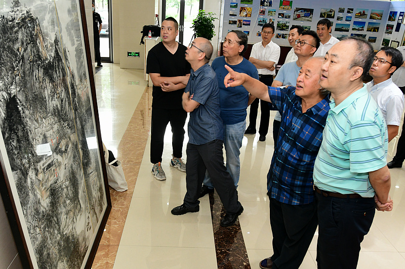 王书平主席与书画家们观赏职工创作的山水画。