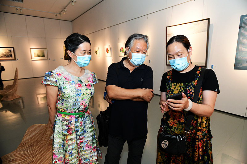 石增琇、谢红、郑寰在画展现场交流。