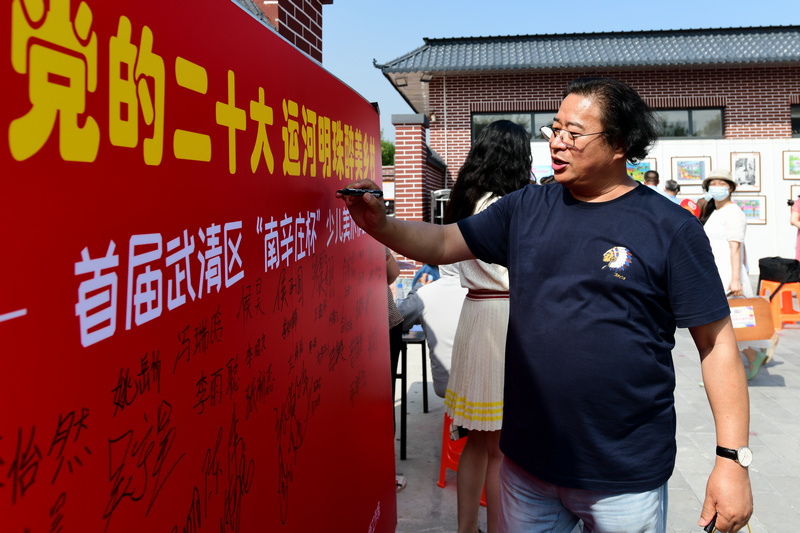 杨东风在展览签到墙上签名。