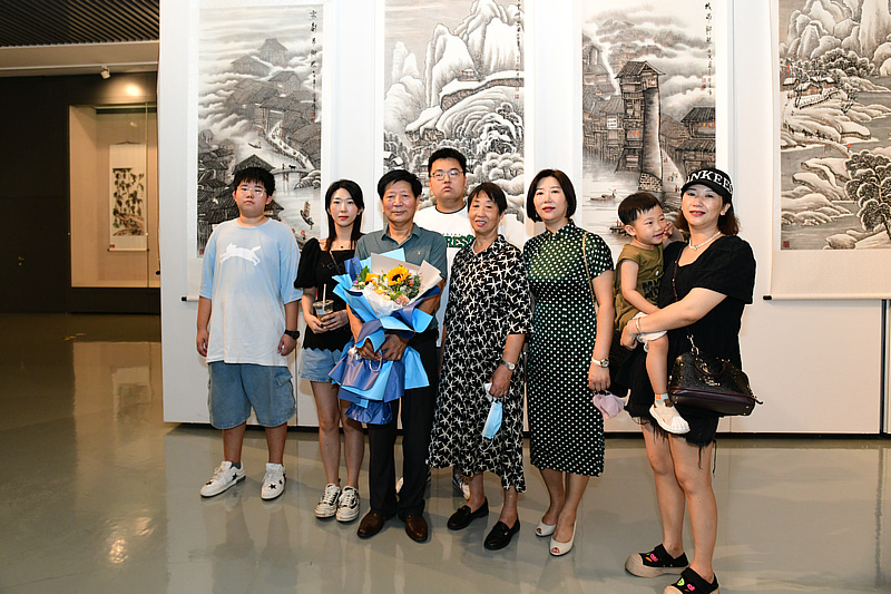 李守玉先生在展览现场拍一张“全家福”。