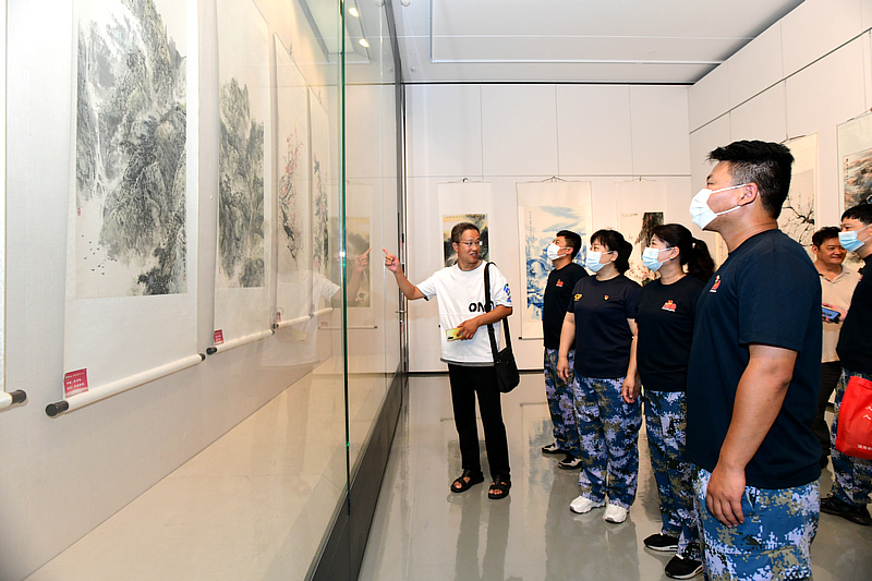刘文月向退役军人介绍展出的作品。