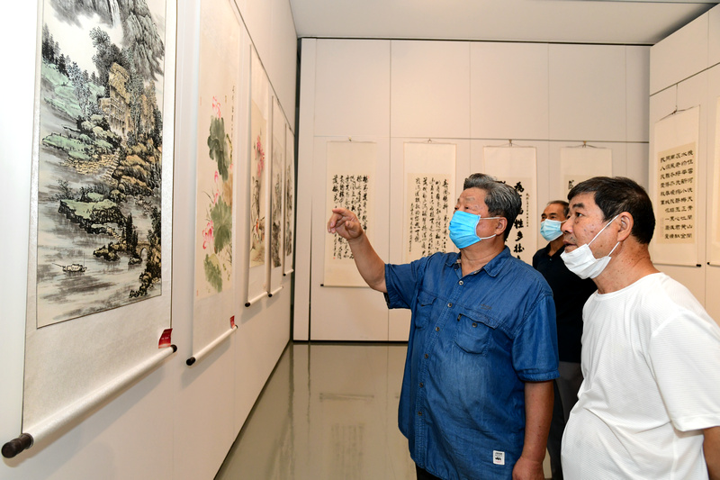 赵海鹏与书画爱好者观赏展出的作品。