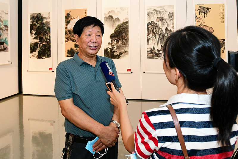 李守玉在展览现场接受媒体采访。