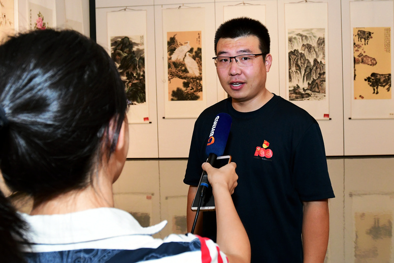 退役军人代表在展览现场接受媒体采访。