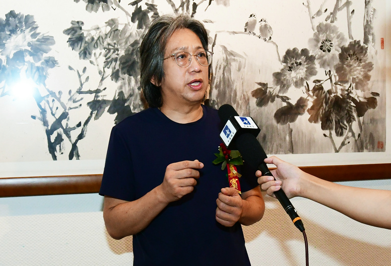 李毅峰先生在画展现场接受媒体采访。