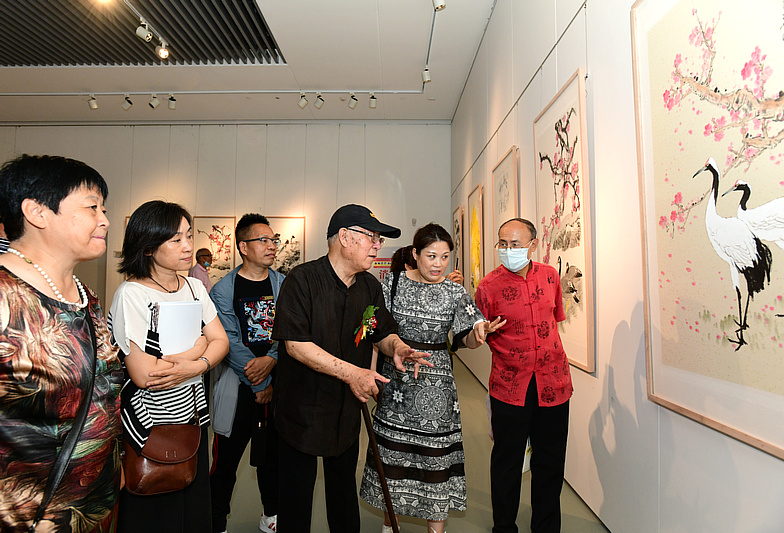 贾宝珉先生与弟子们一起观赏展出的画作。