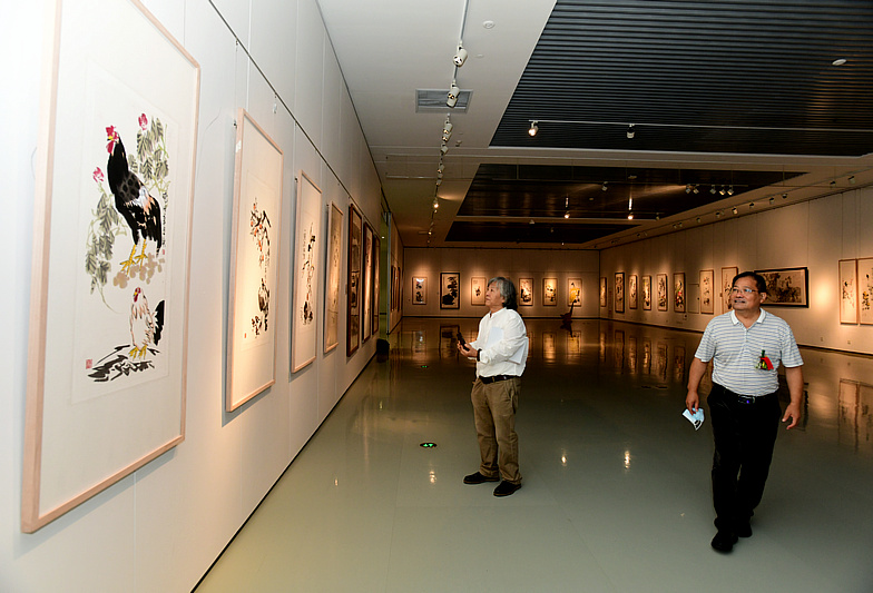 刘向东、周振清观赏展出的画作。