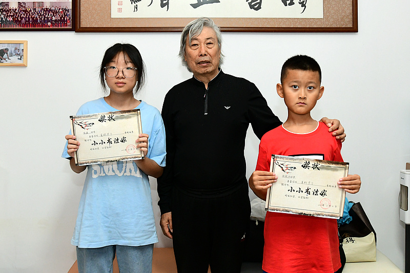 赵家騄为崔颖、张傲沣小朋友颁发“小小书画家”证书。