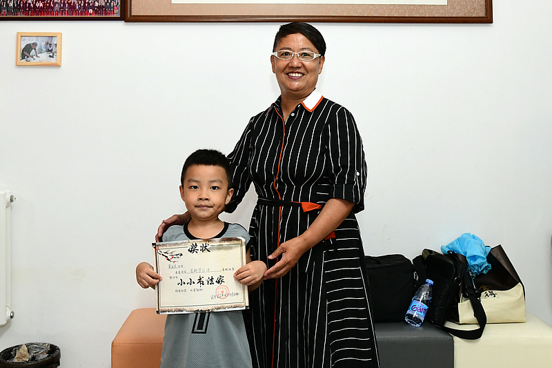 刘英哲老师为刘金晨小朋友颁发“小小书画家”证书。