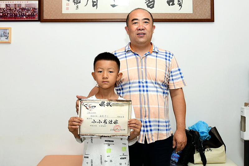 刘洪成老师为刁梓洺小朋友颁发“小小书画家”证书。