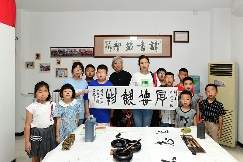 赵家騄老师与仁学书院的小书画家在活动现场。