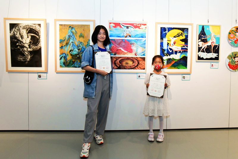 孙敏珠（左）与程钧美同学在展出的作品《大鱼海裳》前