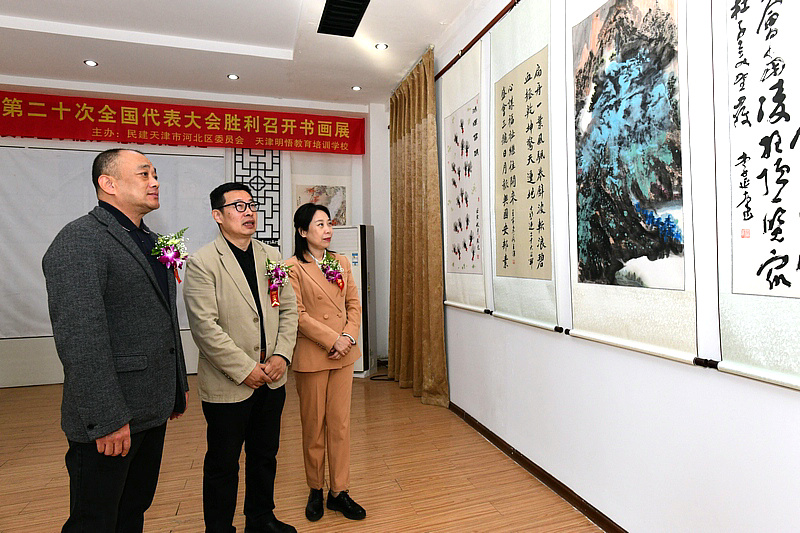 张荃、赵军、曹平在画展现场观赏展出的作品