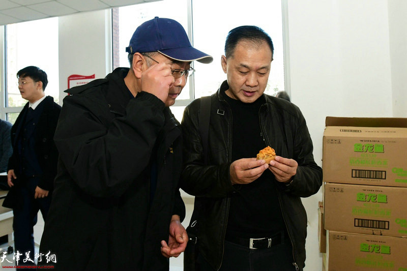 赵全顺在活动现场观赏印石雕刻艺术家卢东的作品。