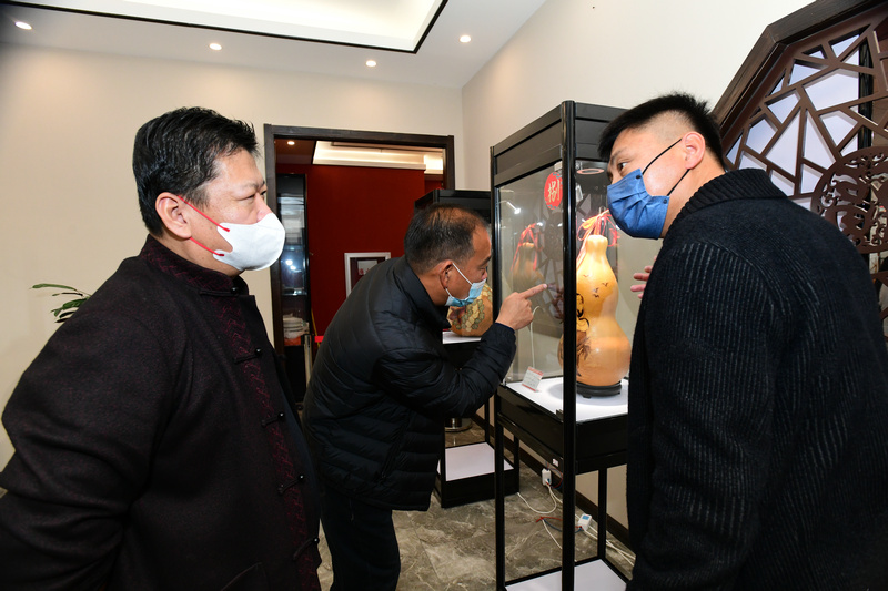 林枫与来宾观赏展出的的葫芦艺术品。