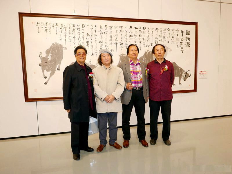 张明光先生（左二）在“百年辉煌”天津湖社美术家作品展现场参展作品前 