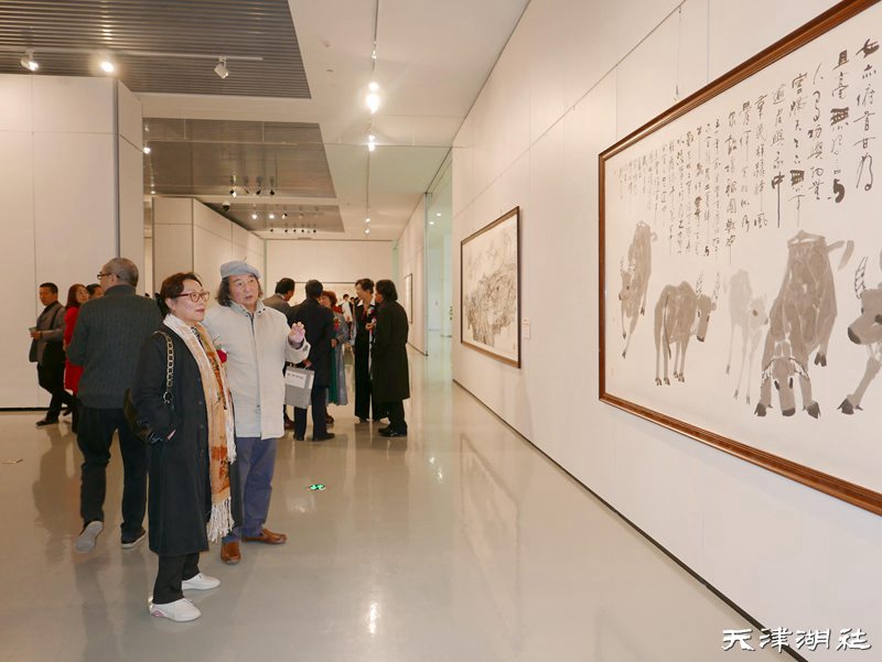 张明光先生（右一）在“百年辉煌”天津湖社美术家作品展现场参展作品前