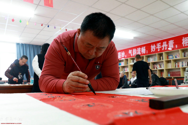 胡家园街道书画爱好者协会会长、义和庄村党总支书记孙玉发现场写春联