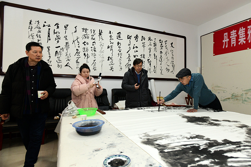 中国书画报艺友会走进芦新河，图为喻建十、路洪明、张福有在活动现场