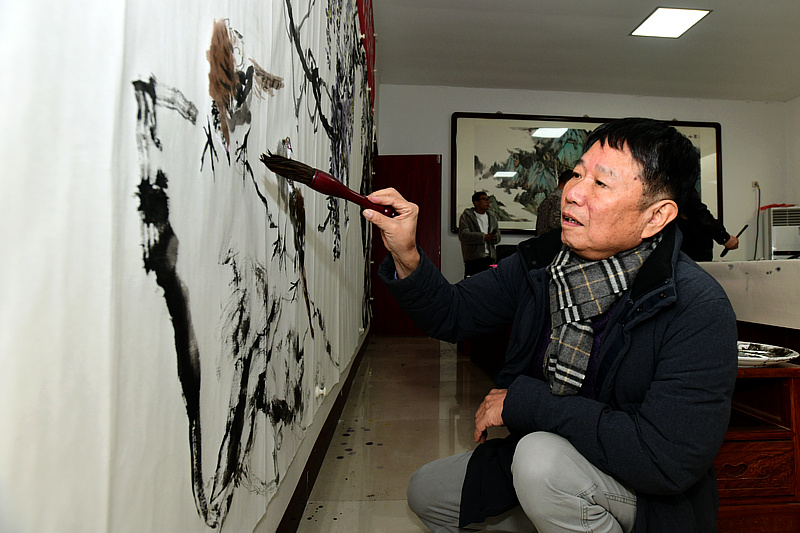中国书画报艺友会走进芦新河，图为刘文生在活动现场创作