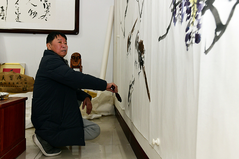 中国书画报艺友会走进芦新河，图为刘文生在活动现场创作