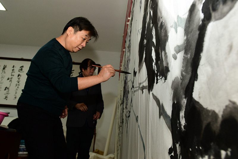 中国书画报艺友会走进芦新河，图为翟鸿涛在活动现场创作